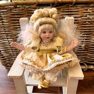 Marie Osmond sitting doll in gold dress with blonde updo hair